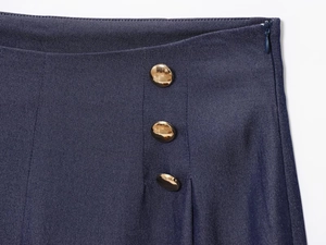 Détail du short bleu marine avec boutons dorés latéraux et fermeture éclair invisible