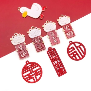 Close-up of DIY Chinese New Year charms featuring red alloy pendants and lucky symbols