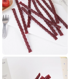Macro detail of dark red spiral licorice candy strips with strawberry props