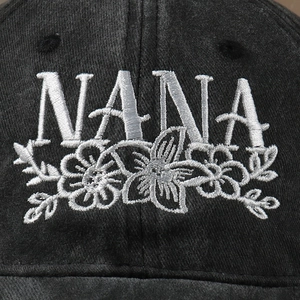 Washed black baseball cap featuring Nana floral embroidery and adjustable strap