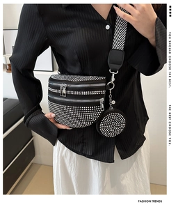 Detail der schwarzen Gürteltasche mit Nieten, runder Tasche und gewebtem Schultergurt