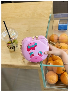 Detailed close-up of pink cartoon animal crossbody bag with golden chain and dual zippers