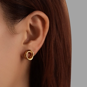Minimalist golden stainless steel coiled flower earrings on model with sleek metallic finish