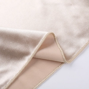 Vue macro du tissu en satin champagne montrant le tissage diagonal et la texture lisse