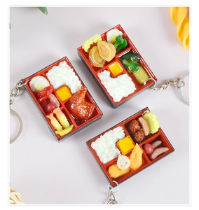 Macro shot of miniature bento box keychains with realistic rice and assorted side dishes