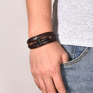 Men's multilayer brown leather bracelet featuring a black cross charm on a male wrist