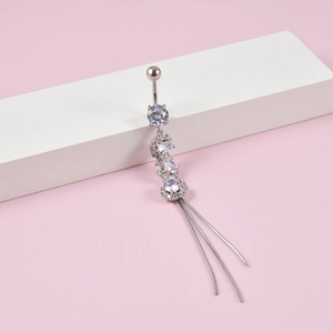 Macro detail of silver stainless steel belly ring with zircon stones and long tassels