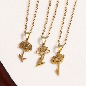 Detailed view of three 18k gold plated stainless steel necklaces with floral engravings