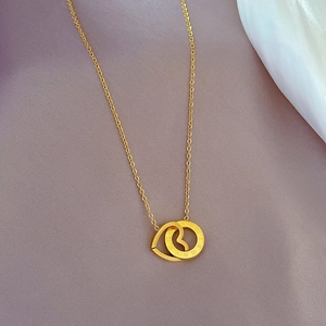 Dettaglio della collana in acciaio al titanio dorato con anelli a cuore e numeri romani