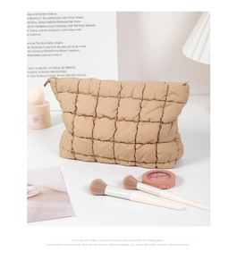 Macro shot of khaki pleated quilted cosmetic bag showing soft fabric texture and zipper