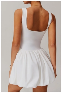 Detail of white mini sports dress showing deep U-shaped back and pleated bubble skirt hem