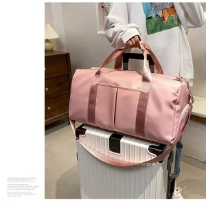 Pink waterproof yoga travel bag with luggage sleeve attachment on white suitcase
