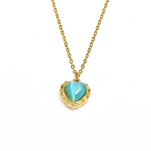 Macro detail of a 18k gold plated necklace with a vintage heart blue cat eye stone