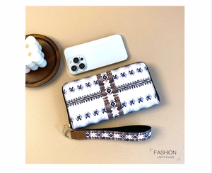Detail of bohemian long wallet with geometric print, wristlet strap, and secure zipper