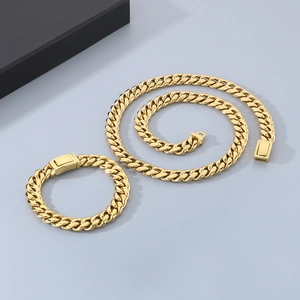 Detailed view of polished golden cuban link necklace and bracelet set on grey surface