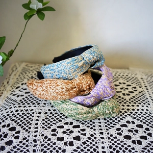 Detailed weave texture of knotted raffia headbands in blue, brown, purple, and green colors