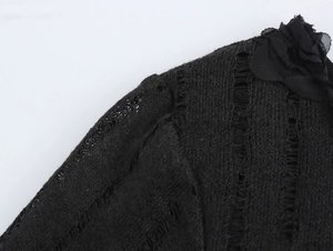 Détail d'une fleur élégante en tricot 3D sur l'épaule d'une robe noire chic
