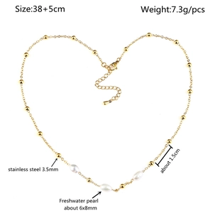 Macro detail of stainless steel beads and freshwater pearls on a heart-shaped necklace