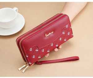 Detailed view of red quilted long wallet with golden zipper and wristlet strap