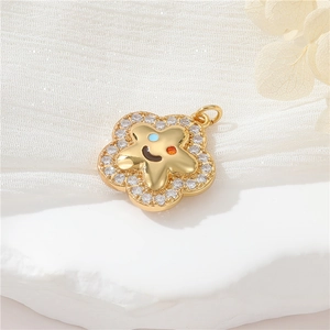 Macro shot of gold flower smile face pendant with colorful gems and zircon details