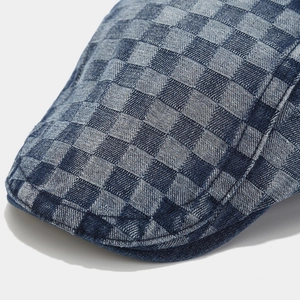 Macro shot of checkered denim fabric and stitching on a vintage navy flat cap