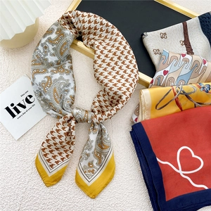 Elegant silk scarf set with houndstooth and paisley prints on white textured surface