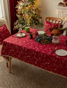 Close-up of red Christmas tablecloth with jacquard reindeer and bell patterns on table