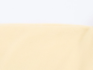Close-up of the beige wool-like fabric texture with soft fiber detail and premium finish