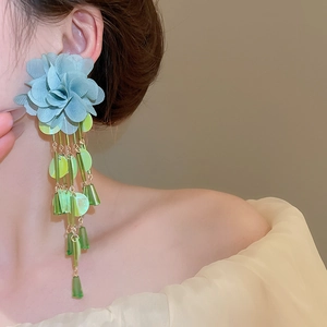 Detail of floral chiffon tassel earrings with light blue fabric and green resin beads