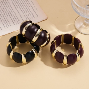 Retro acrylic block bracelet with gold beads in black and burgundy tones on book background