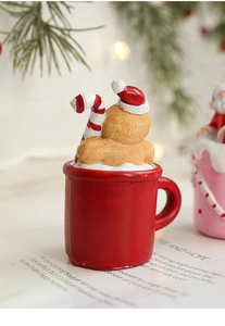 Close-up of resin gingerbread man in red mug with cane and warm bokeh background