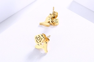 Detailed view of polished golden rose flower stud earrings with butterfly backings