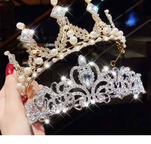 Detailed view of luxury gold pearl and silver rhinestone tiaras for girls' parties