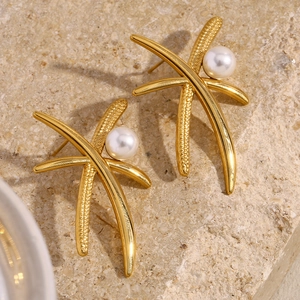 Detailed macro view of 18K gold plated coconut tree pearl earrings on stone surface