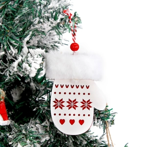 White wooden Christmas glove ornament with faux fur trim hanging on a snowy pine branch