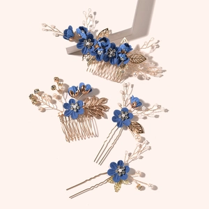 Detailed view of bridal hair set with blue fabric flowers and golden metal leaves