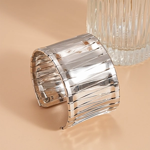 Detail of silver metallic wide open cuff bracelet with layered ribbed texture finish