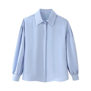 Flat lay of light blue long-sleeved shirt with classic collar and lantern sleeves