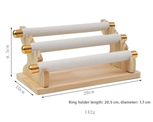 Detailed view of 3-tier wooden jewelry stand with white velvet bars and gold ball accents