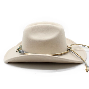 Detail of cream wool cowboy hat featuring a colorful braided band and metal star pendant