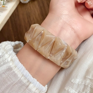 Macro detail of geometric marble-pattern acrylic resin triangular elastic bracelet