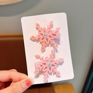 Close-up of pink glitter snowflake hair clips with faux gems for girls
