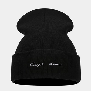 Detail of black knit beanie featuring white Carpe Diem cursive embroidery on the cuff