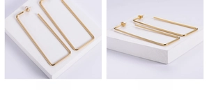 Detailed view of large gold rectangular hoop earrings with minimalist thin wire design