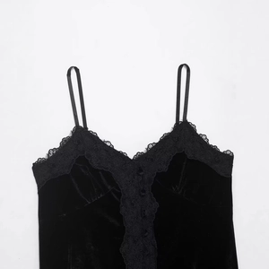 Flach liegendes schwarzes Samt-Camisole-Top mit Spitzenbesatz und Zierknöpfen auf Weiß