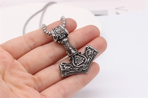 Detailed view of vintage silver Mjölnir pendant with Valknut symbol on square pearl chain