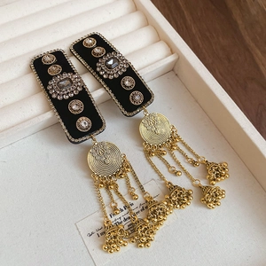 Detail of ethnic retro tassel earrings with bells and crystals on jewelry tray
