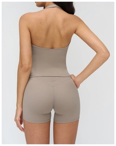 Detail of a taupe V-neck halter yoga top with backless design and high-waisted shorts