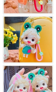 Detail of cute doll keychain with movable limbs on a yellow bag featuring green heart dress