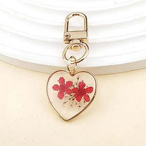 Heart-shaped resin keychain with red dried flowers and gold-plated metal clasp pendant